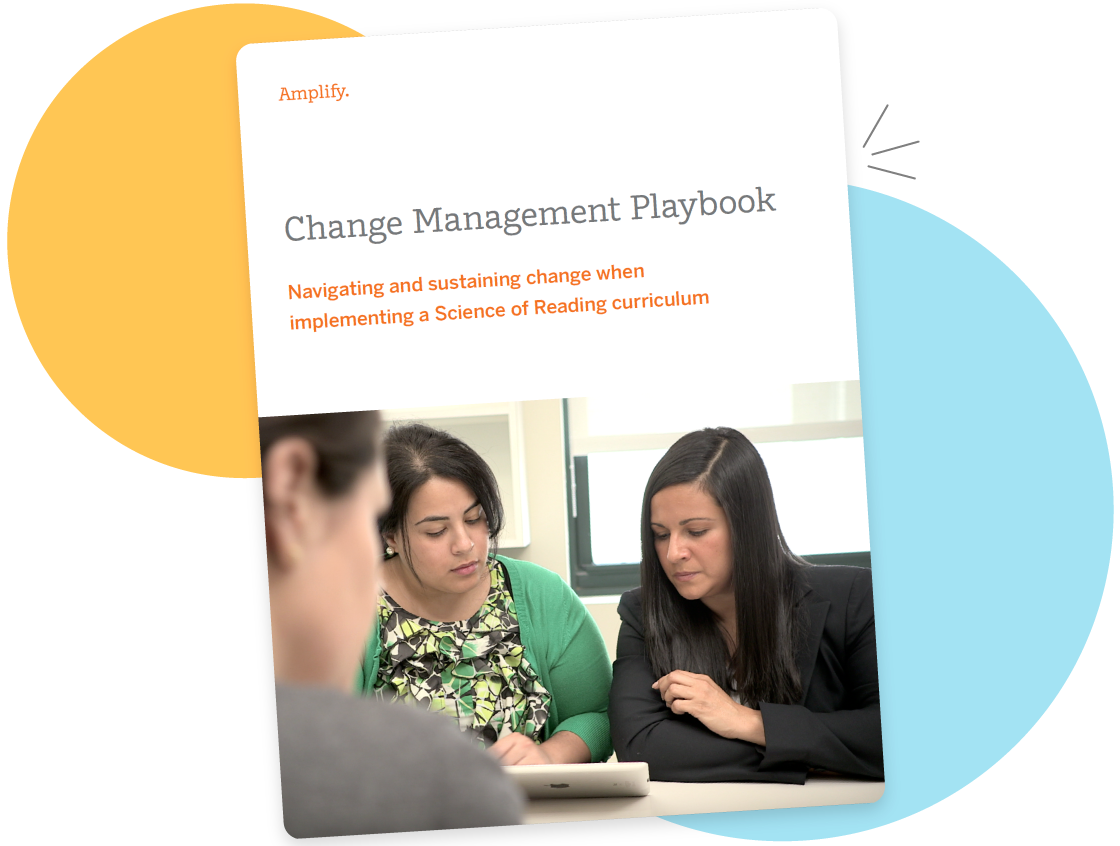 Two women reviewing a "change management playbook" on literacy intervention on a laptop in an office setting.