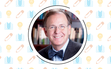 A person in a suit and bow tie smiles in front of a bookshelf, embodying the art of building to impact. The background is adorned with a pattern of books, pencils, and lightbulbs.