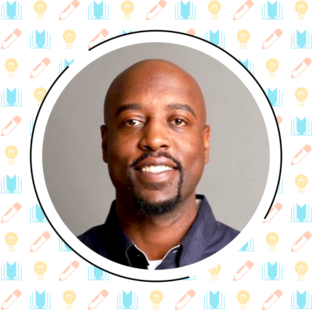 A bald man with a goatee is smiling in a portrait photo. The background, hinting at the world of literacy instruction, has a charming pattern of lightbulbs, pencils, and books.