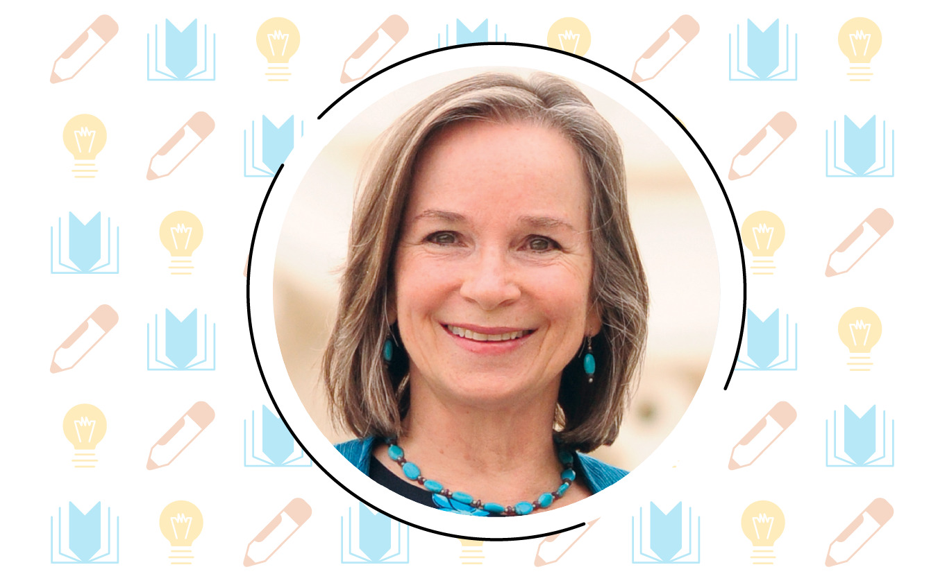 A smiling person with shoulder-length gray hair, adorned in turquoise earrings and a necklace, stands against a patterned background featuring books and light bulbs—an inspiring nod to literacy instruction.