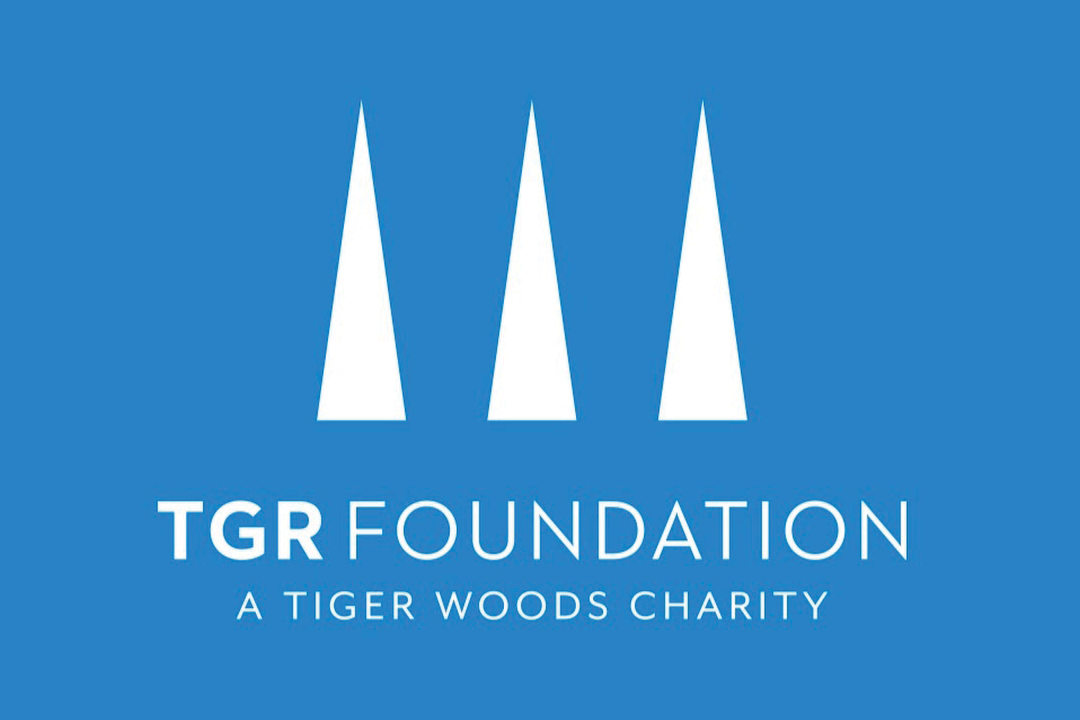 Logo for TGR Foundation, a Tiger Woods charity. It features three white triangular shapes on a blue background with the text "TGR FOUNDATION A TIGER WOODS CHARITY" beneath them.