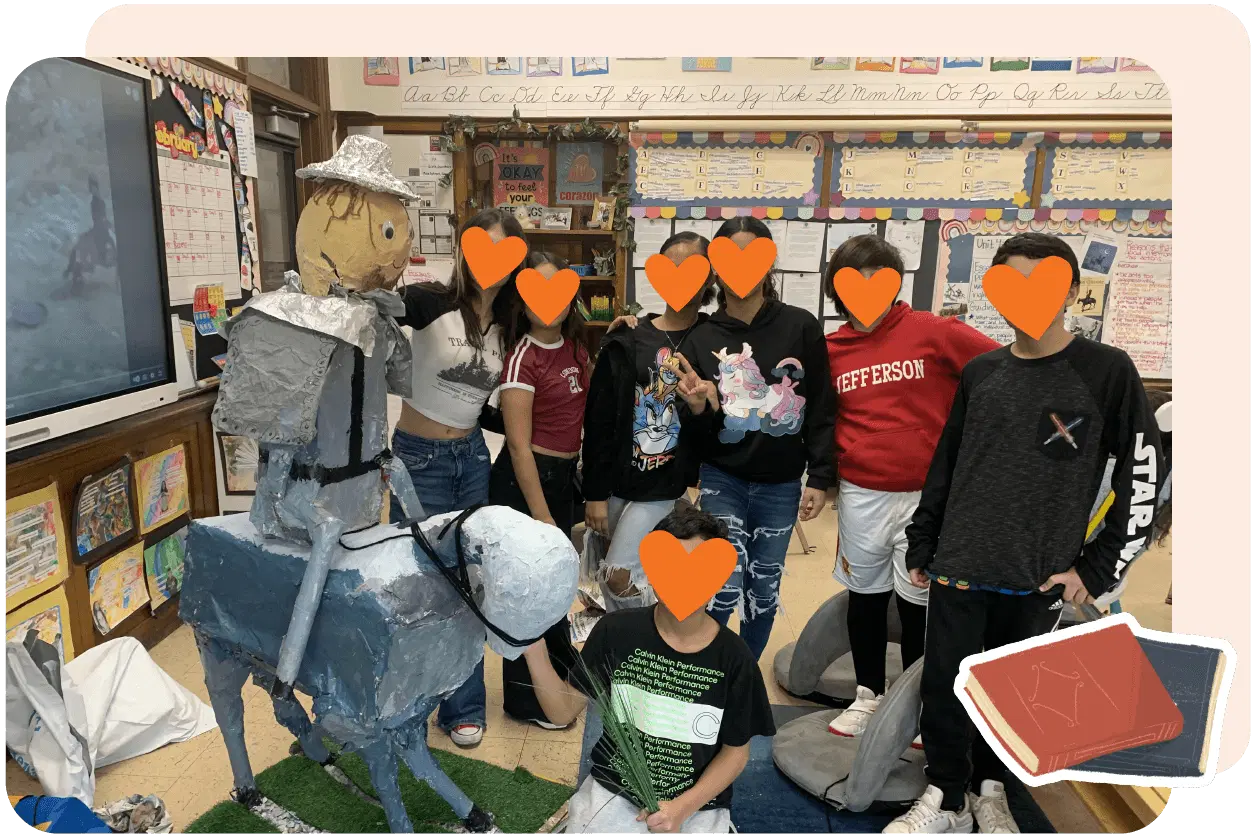 Classroom with students posing around a paper-mache structure resembling a knight on a horse, colorful educational posters lining the walls.