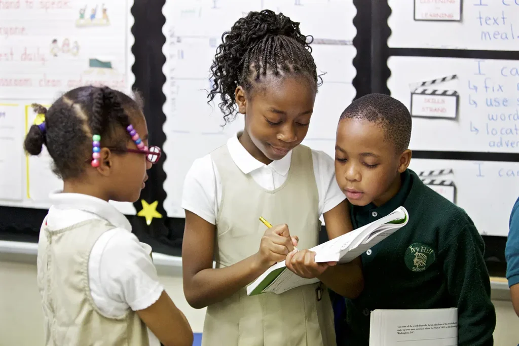 Three children looking at an open book